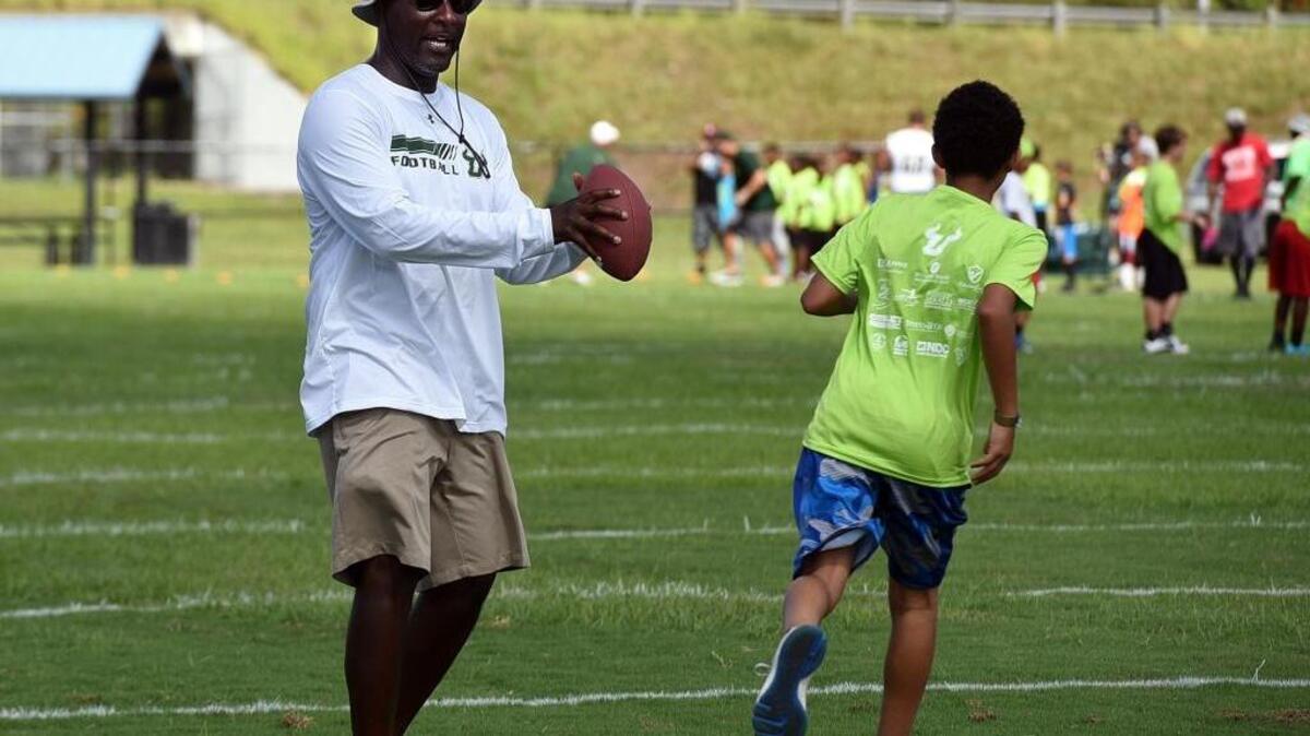 Former Palmetto football coach Ray Woodie works with youth during a football camp at Lincoln Park in Palmetto.