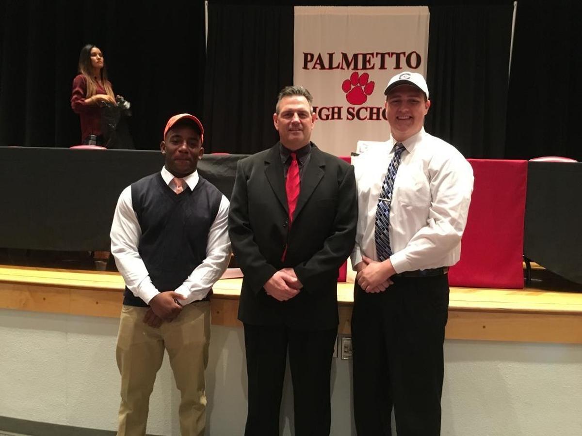 Palmetto High head football coach Dave Marino is flanked by captains Alonzo Houston (left) and Jesse West (right) on Wednesday.