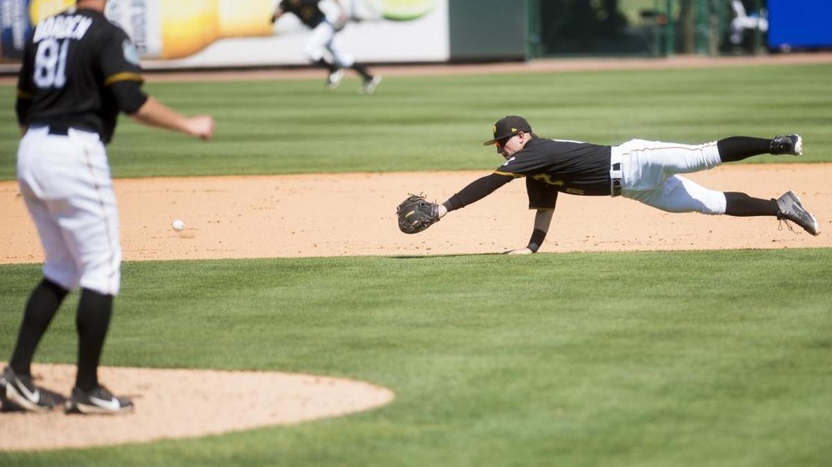 Pittsburgh Pirates second baseman Cody Dickson dives for a ground ball during Wednesday’s spring training game against the Philadelphia Phillies at LECOM Park in Bradenton.