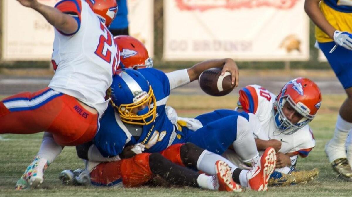 Bayshore's Corey Vonborstel hangs onto the ball as he's tackled by Southeast defenders as Southeast faces off against Bayshore on Thursday evening at Bayshore High School in Bradenton.