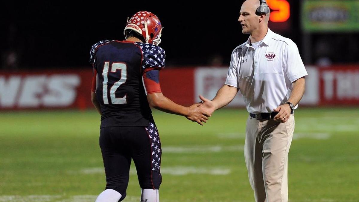 Manatee coach John Booth, right, greets A.J. Colagiovanni as the latter returns to the sideline during a 2016 game at Kinnan Field.