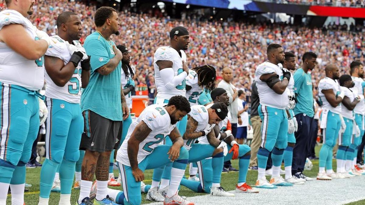 Miami Dolphins Arian Foster (29) wide receiver Kenny Stills (10) and free safety Michael Thomas (31) take a knee during the National Anthem before the game as the New England Patriots host the Miami Dolphins at Gillette Stadium on Sunday, September 18, 2016.