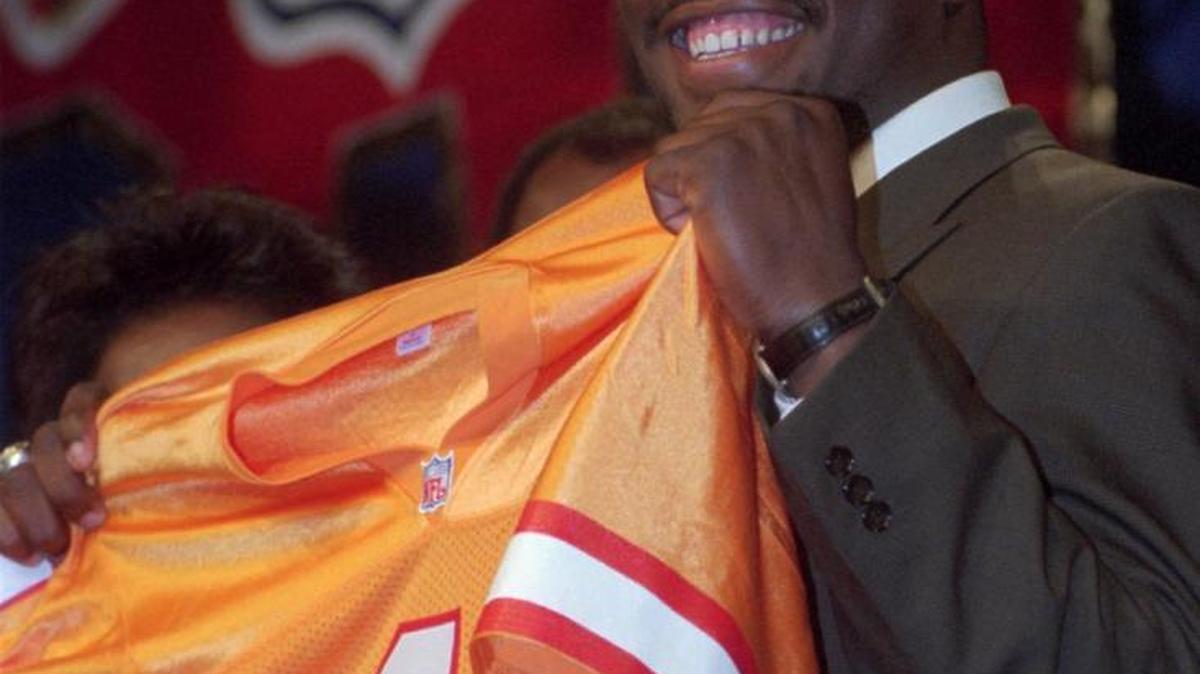 Miami’s Warren Sapp smiles while holding his new Tampa Bay jersey after being the 12th overall pick in the 1995 draft.
