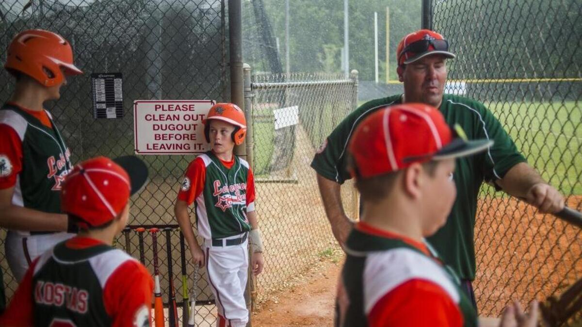 Lakewood Ranch players take shelter from the rain before thunderstorms cancelled their game against Braden River Little League District 26 All-Star Tournament on Thursday evening at Buffalo Creek Park in Palmetto.