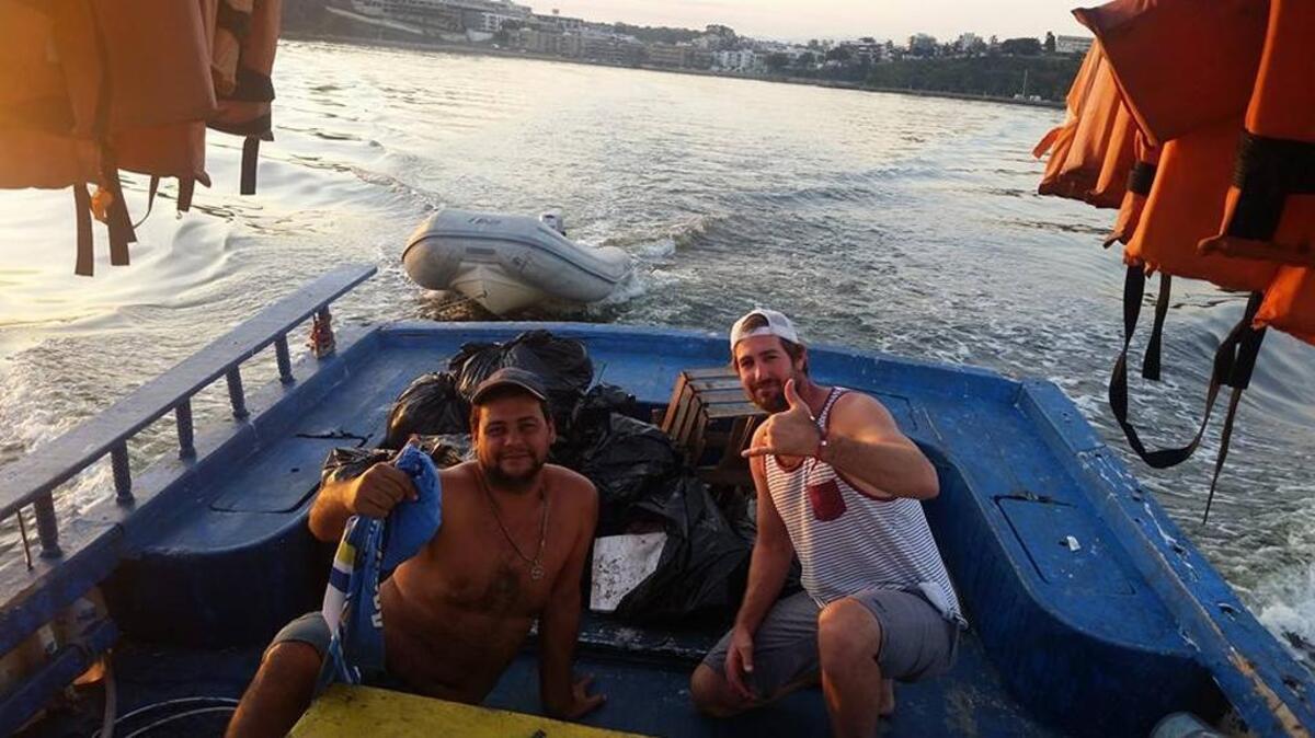 Fort Lauderdale’s Brad Funk, right, shows off the bags of trash he and Julio do Outeiral Filho, a fishing boat captain in Niteroi, pulled out of Guanabara Bay recently in preparation for the sailing events in the Rio Olympics.