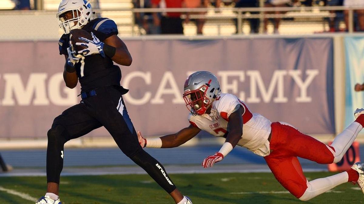 IMG's Brian Hightower runs for the goal line as he outruns St. Johns' DJ Brown at IMG's home game Saturday night in Bradenton.