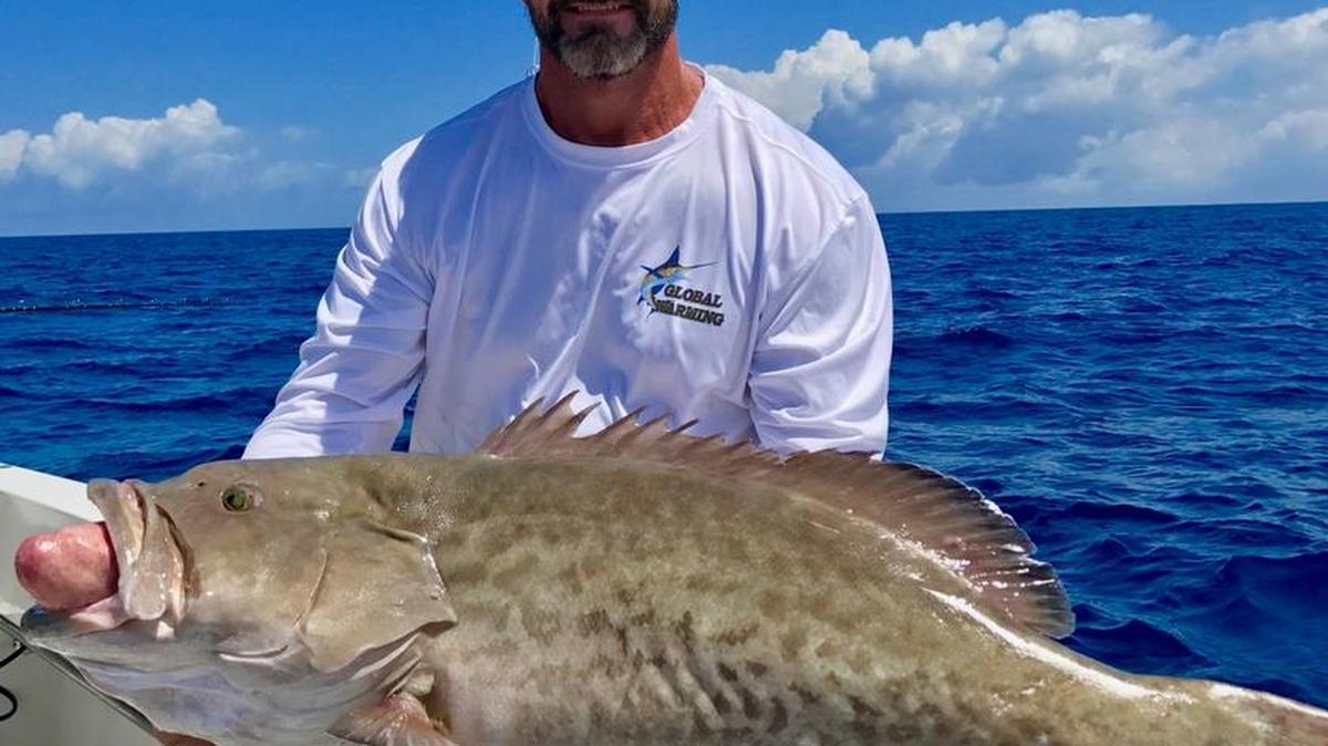 Capt. Brian Morgan holds a 20-pound gag grouper he caught in 180 feet of water.