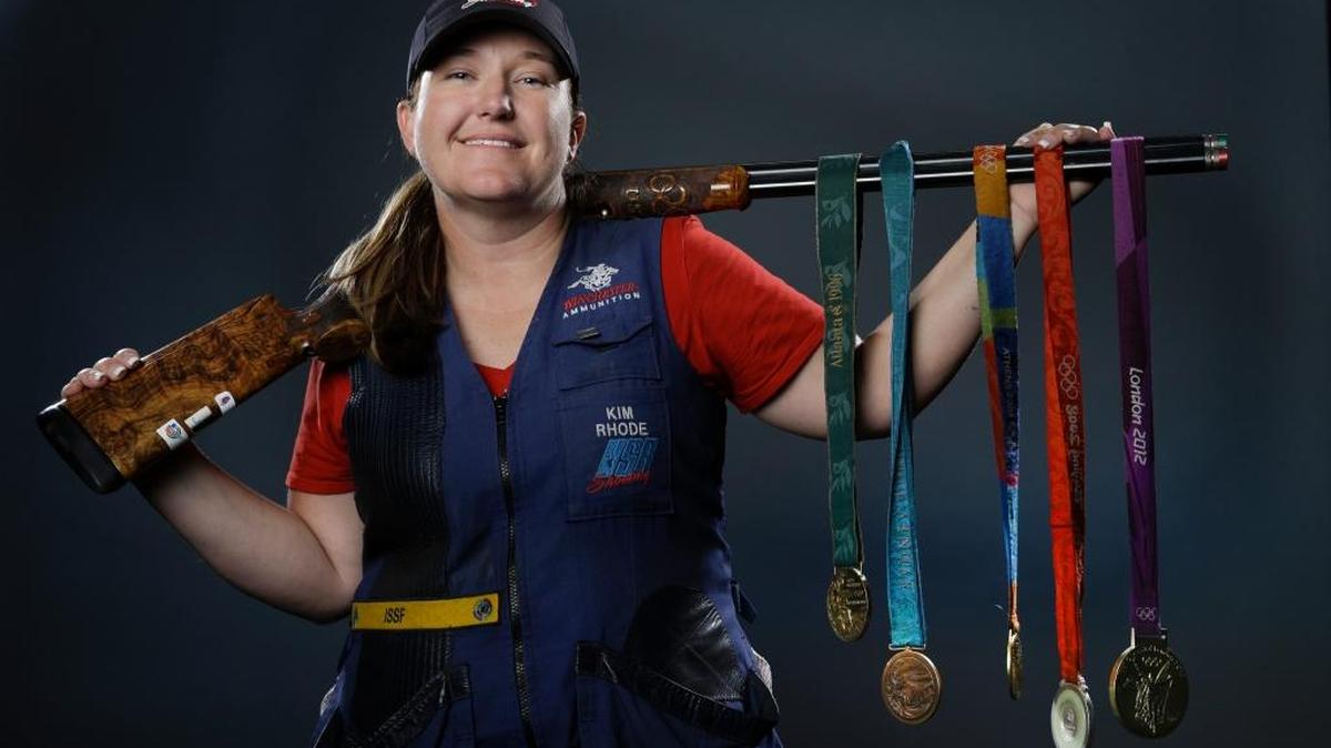 In this March 8, 2016, file photo, double trap and skeet shooter Kim Rhode poses for photos with her Olympic medals at the 2016 Team USA media summit in Beverly Hills, Calif. Misfortune stacked up like spent shotgun shells in the four years since Kim Rhode won her third Olympic gold medal.
