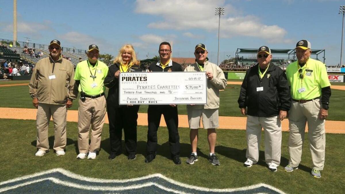 Bradenton Booster President Jim Clark, extreme left, joins fellow organization officers Mike Roteman (from left), Debbie Tropeck, Pirates Senior Director of Florida Operations Jeff Podobnik, Booster club officer Jack Emery and longtime Booster members Dick Davis and Bill Carltin during the onfield presentation.