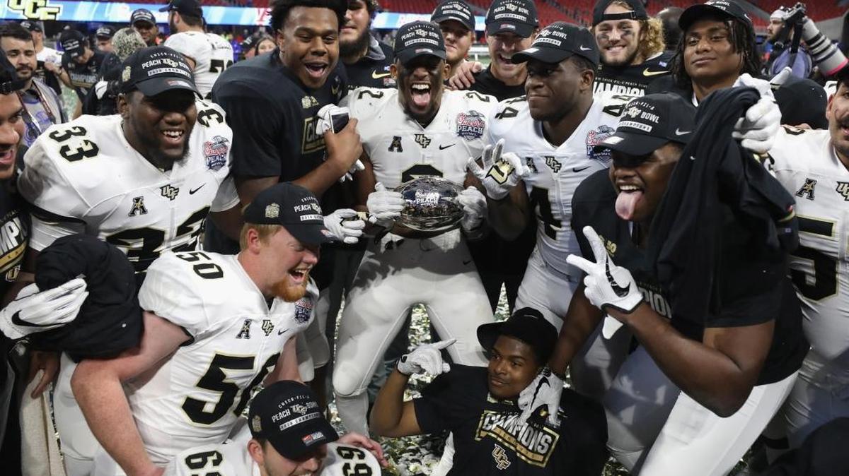 The UCF Knights celebrate defeating the Auburn Tigers 34-27 to win the Chick-fil-A Peach Bowl at Mercedes-Benz Stadium on January 1, 2018 in Atlanta, Georgia.