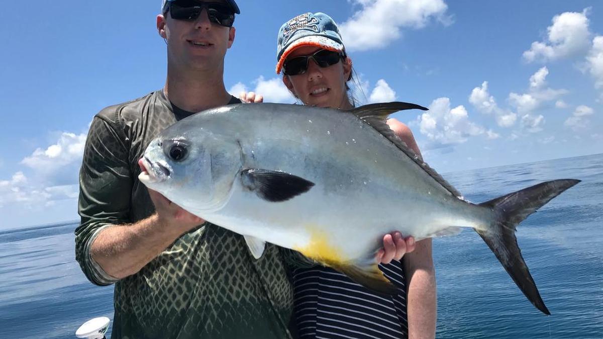 Geoff and Linnea Szymanski hold a permit caught by Linnea on a pass crab in the Gulf of Mexico during a recent fishing trip.