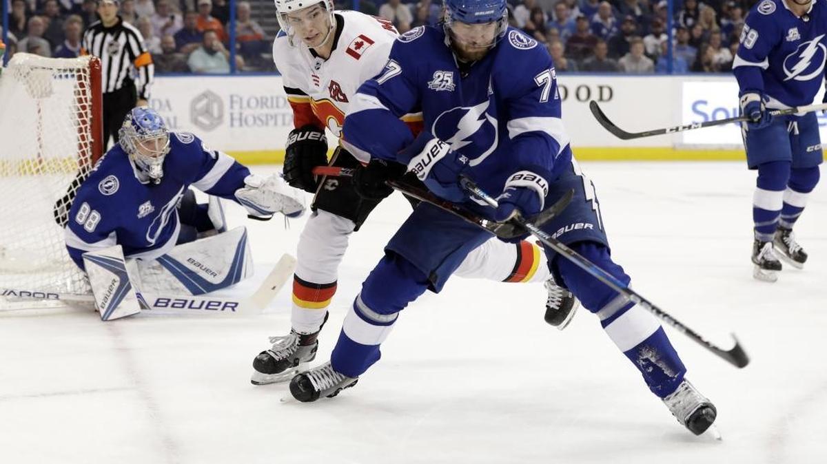 Tampa Bay Lightning defenseman Victor Hedman (77), of Sweden, beats Calgary Flames center Sean Monahan (23) to the puck in front of goaltender Andrei Vasilevskiy (88) during the first period of an NHL hockey game Thursday, Jan. 11, 2018, in Tampa, Fla.