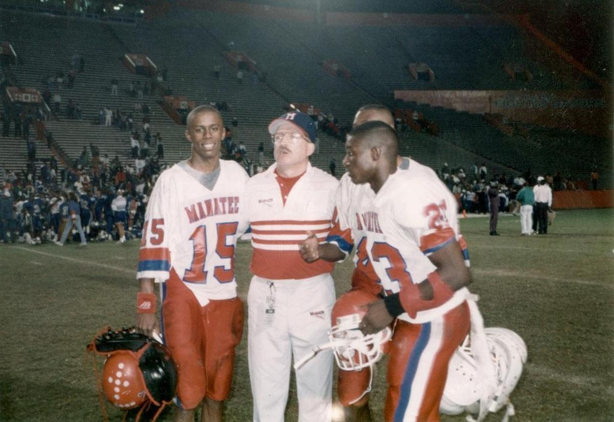 Manatee High quarterback Willie Taggart, left, celebrates the 1992 Class 5A state title with position coach Frank Turner and a pair of teammates.