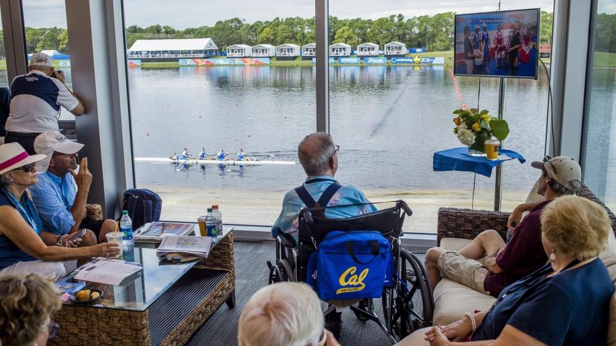 Spectators watch the awards ceremony on a small television in the VIP section of the World Rowing Championships during Saturday’s finals at Nathan Benderson Park in Sarasota.
