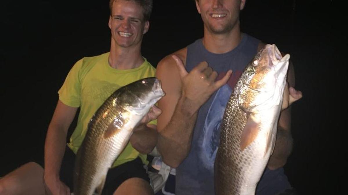 Anglers Colton Cook and Chris Jensen hoist a pair of redfish they caught at night after Hurricane Irma.