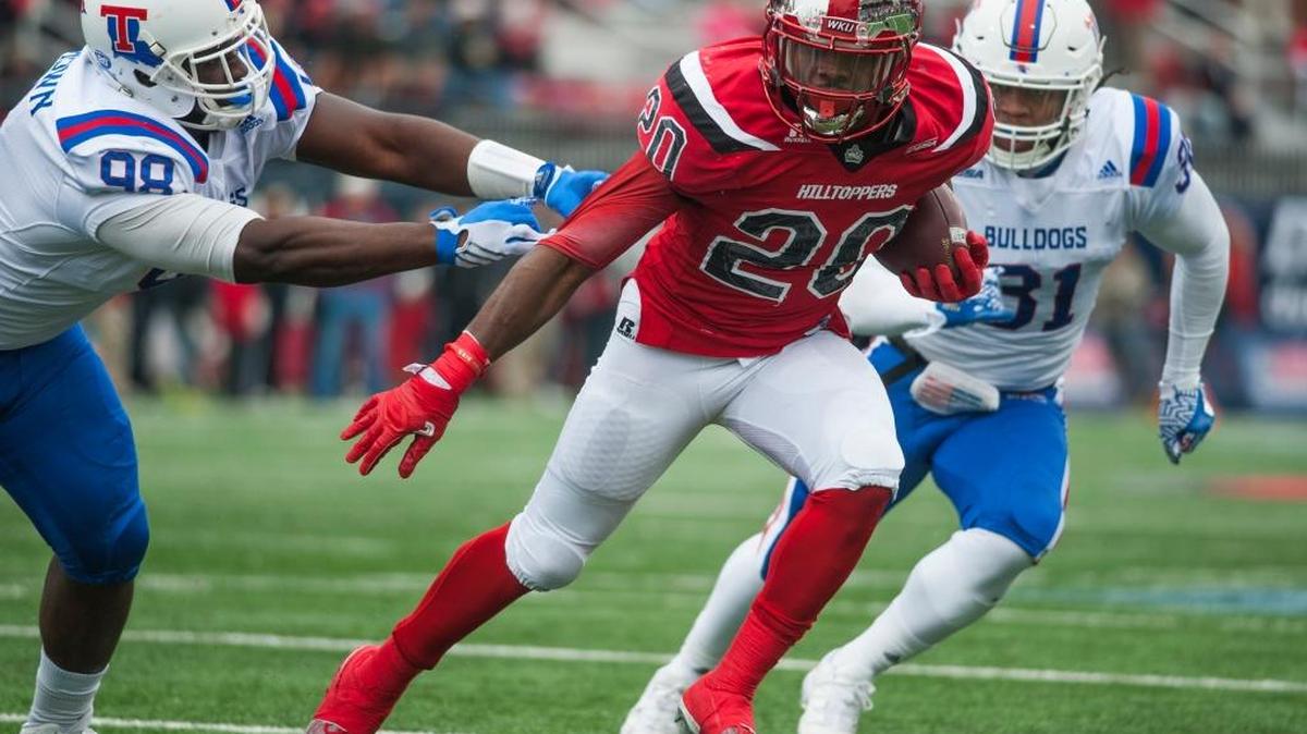 Western Kentucky running back Anthony Wales breaks a tackle attempt by Louisiana Tech defensive lineman Aaron Brown during the Conference USA championship NCAA college football game Saturday in Bowling Green, Ky.
