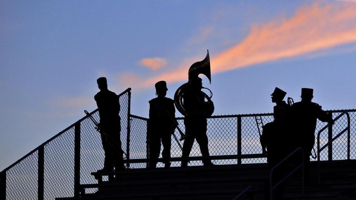 Bayshore Band members are outlined against a darkening sky at Bayshore’s Balvanz Stadium Friday night.