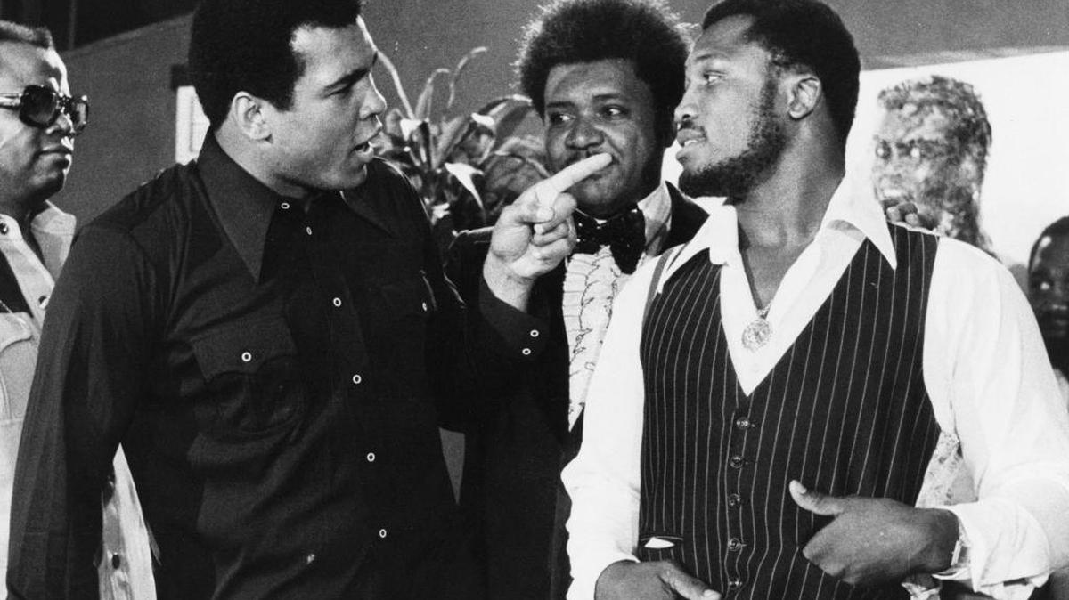 In this July 17, 1975, file photo, sports promoter Don King stands between Muhammad Ali, left, the heavyweight champion, and Joe Frazier in New York. Ali, the magnificent heavyweight champion whose fast fists and irrepressible personality transcended sports and captivated the world, has died according to a statement released by his family Friday, June 3, 2016. He was 74.