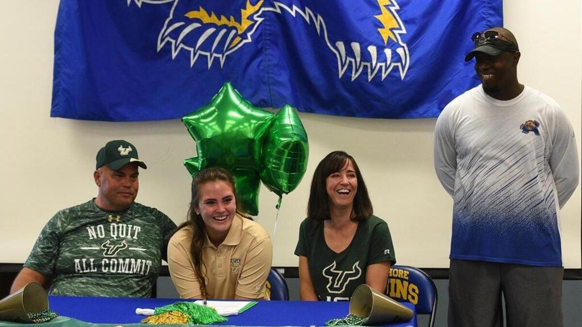 Bayshore High softball coach Frank Luther, right, has resigned. His former pitcher Miriam Schmoll, with parents Shawn and Stacy, is now at USF.