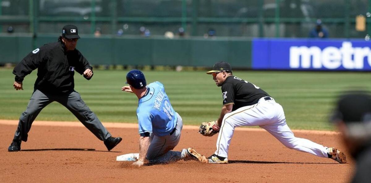 The Rays’ Joey Wendle slides in safely at second base as the Pirates’ Adam Frazier is late with the tag.